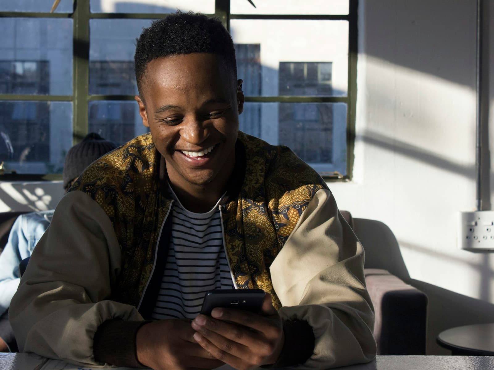 A man smiling at a payment notification on his phone